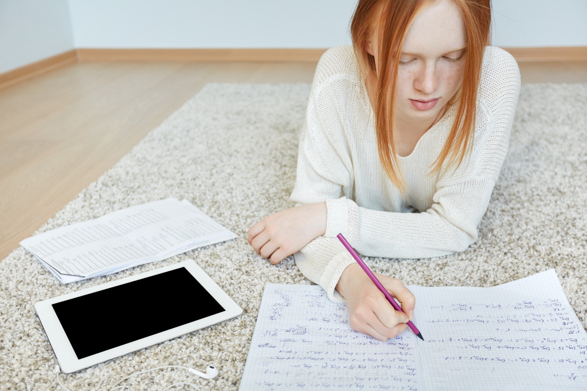 Rude kobiety leżącej na podłodze z notebookiem i tabletem