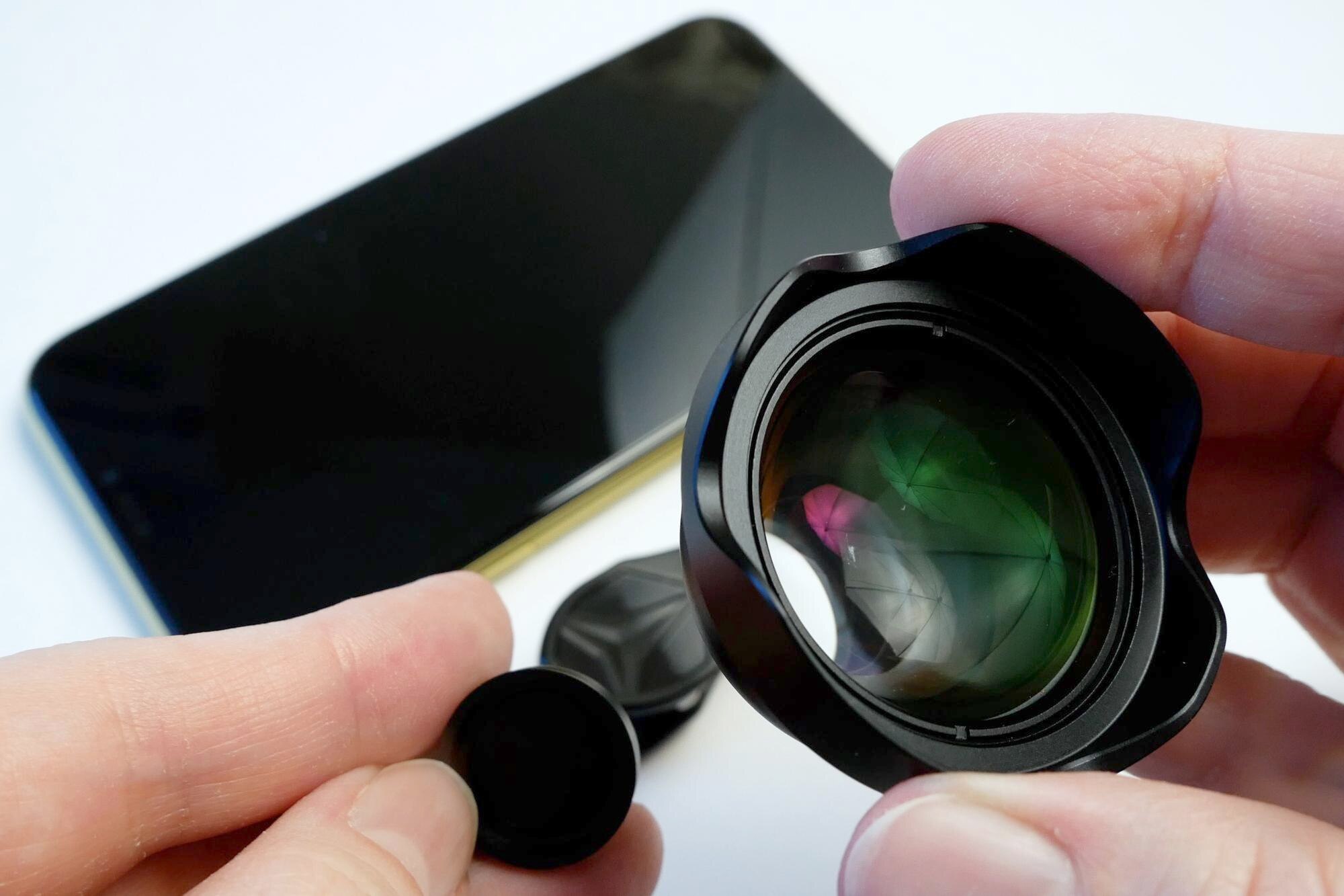 żółty smartfon z zewnętrznym obiektywem na klipie na białym dodatkowy obiektyw portretowy