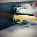 Odcięta ręka osoby wkładającej kabel do maszyny