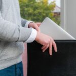 Młody biznesmen wyciągając laptopa z skórzanego etui w biurze.