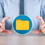 Biznesmen przytrzymaj ikonę folderuDocument Management System lub konfiguracja DMS przez konsultanta IT z nowoczesnym komputerem wyszukują zarządzanie informacjami i plikami firmowymiPrzetwarzanie biznesowe