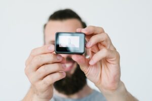 Nowoczesna technologia tworzenia treści wideo człowiek trzymający kamerę akcji i nagrywający sam sprzęt i narzędzia blogera