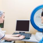 Dziewczyna optometrystka bada oczy pacjenta za pomocą specjalnego nowoczesnego sprzętu