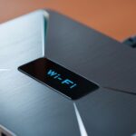 Nowoczesny router na drewnianym stole symbolizujący łączność domową i technologię
