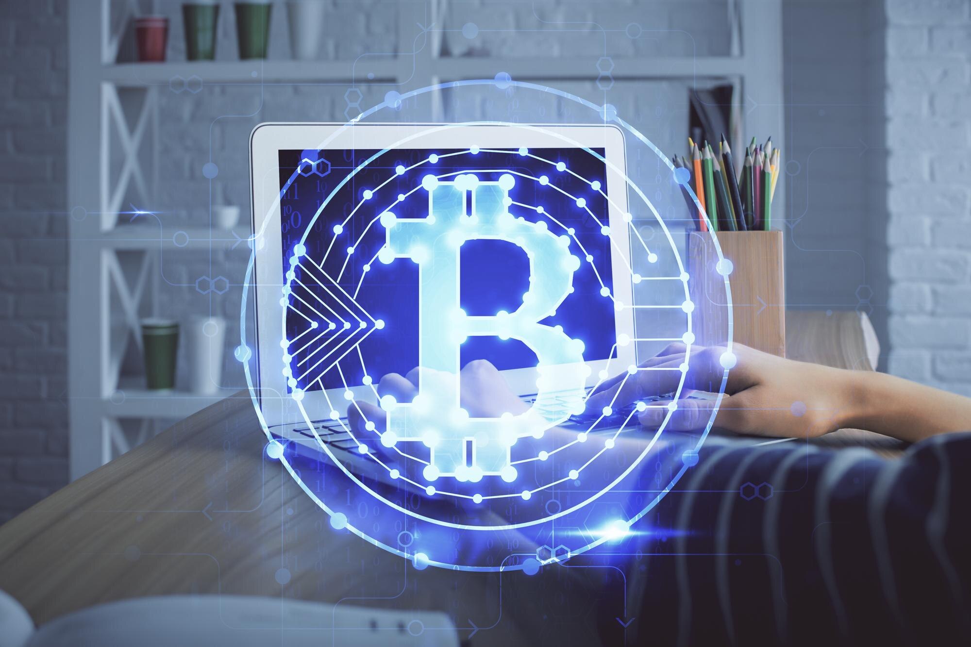 Podwójna ekspozycja kobiecych rąk piszących na komputerze i hologram motywu rynku kryptowalut rysujący koncepcję Blockchain