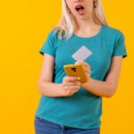 Nierozpoznawalna osoba w płatności online kartą na żółtym tle studia telefonicznego