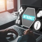 Koncepcja intranetu Kobieta biznesowa korzystająca z laptopa na biurku z ikoną intranetu na wirtualnym ekranie udostępnianie narzędzi współpracy informacyjnej i innych usług obliczeniowych