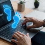 para świecących niebieskich cyfrowych odcisków stóp na ekranie laptopa używanego przez osobę