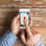 koncepcja ludzi, nawigacji i technologii - zbliżenie męskich rąk trzymających smartfon z mapą nawigatora gps