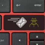 Klawiatura laptopa z symbolami koperty i oszusta Haker wysyła wiadomość phishingową, aby uwięzić ofiarę