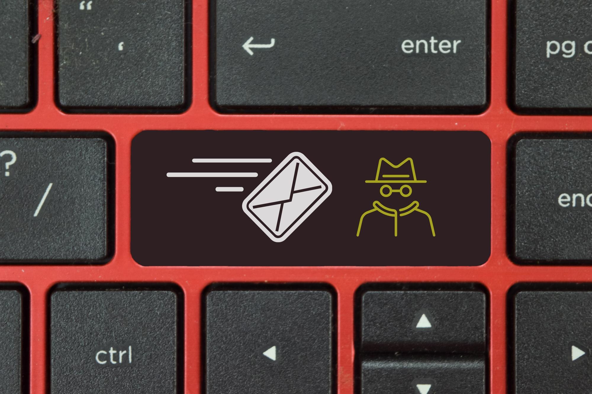 Klawiatura laptopa z symbolami koperty i oszusta Haker wysyła wiadomość phishingową, aby uwięzić ofiarę