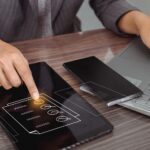 Bizneswoman korzystająca z laptopa i dotykająca kwestionariusza kontaktowego na wirtualnym ekranie z polami wyboru