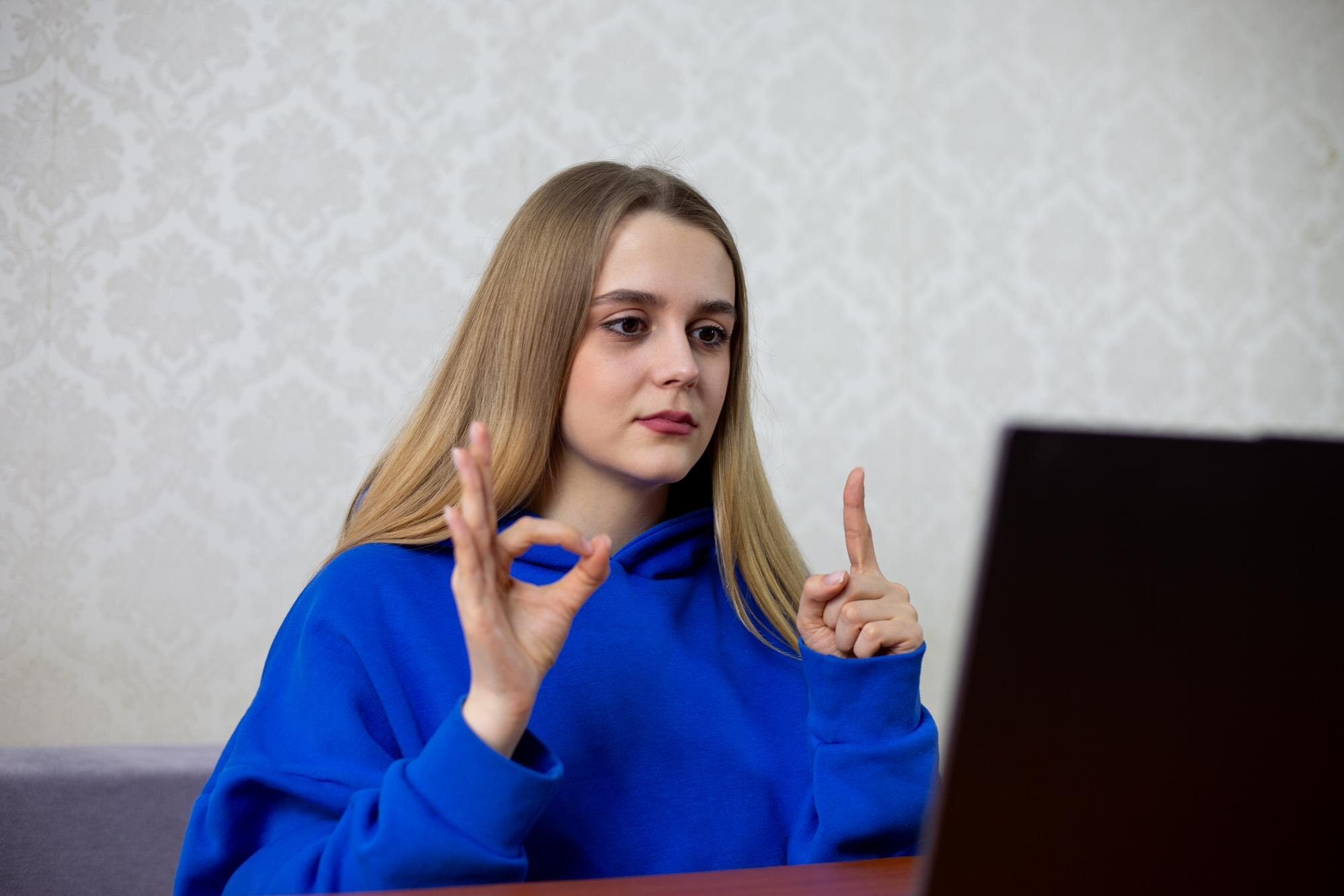 Confident blonde football fan displays one finger and zero showing 10 score She calmly celebrates her team leading match with minimal advantage Satisfied supporter at home