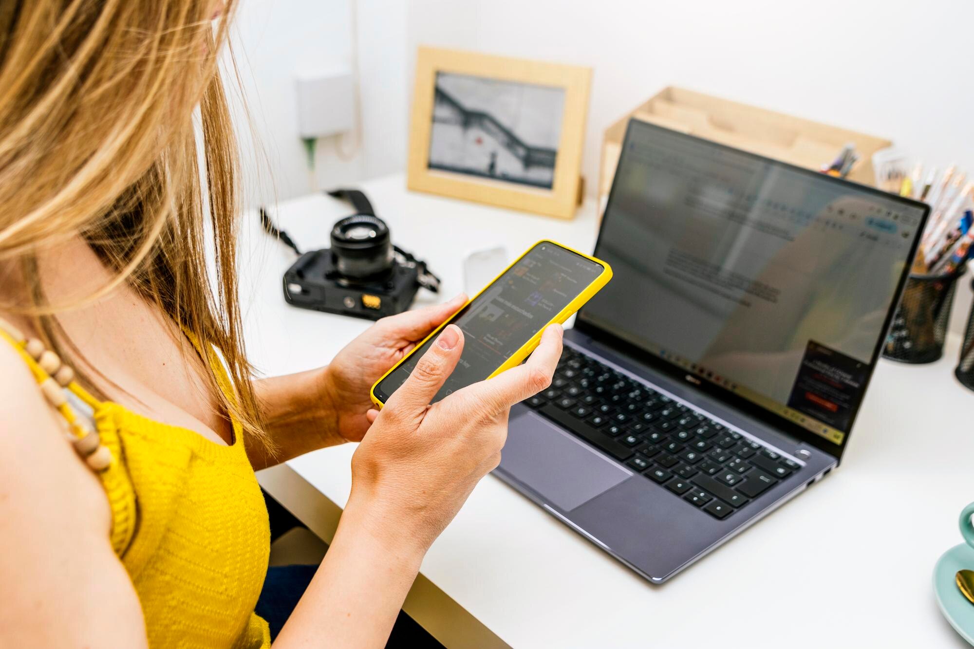 Zbliżenie Businesswoman z żółtą koszulą przy użyciu telefonu z pracy w domu