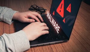 Kobieta korzystająca z laptopa z ostrzeżeniem o wirtualnym złośliwym oprogramowaniu Koncepcja zhakowania systemu Cyberatak na komputer