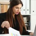 Pięknej brunetki bizneswomanu uśmiechnięta praca z laptopem