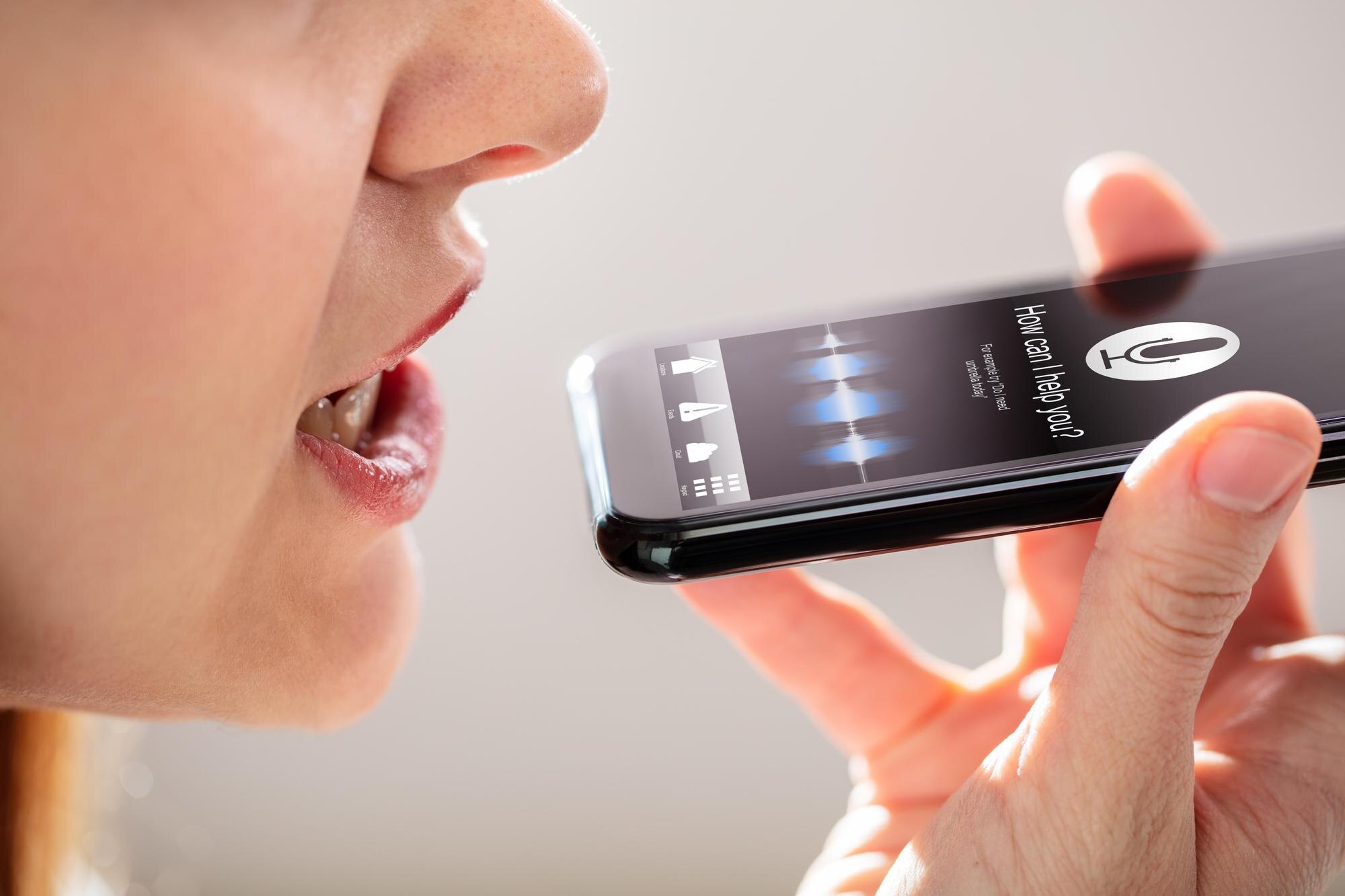 Kobieta korzystająca z funkcji rozpoznawania głosu w telefonie komórkowym