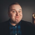 Bitcoin w grubej zabawnej dłoni człowieka, symbol cyfrowej nowej wirtualnej waluty