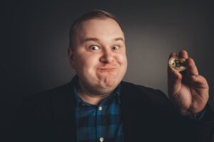 Bitcoin w grubej zabawnej dłoni człowieka, symbol cyfrowej nowej wirtualnej waluty