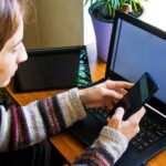 Kobieta pracująca w biurze z cyfrowym tabletem i notebookem pisząc i pisząc na urządzeniu