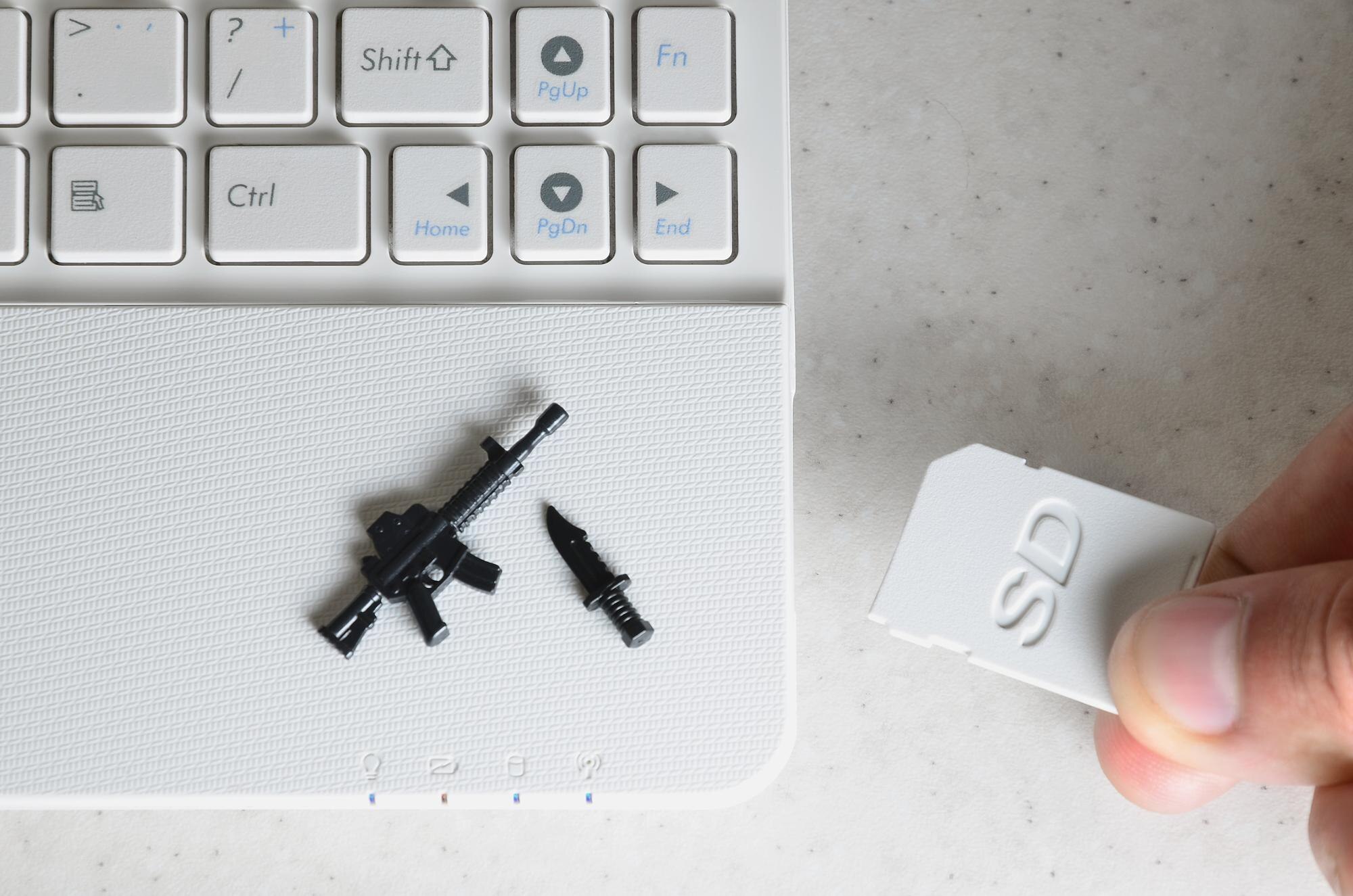 Przycięta ręka wkładająca kartę pamięci do laptopa